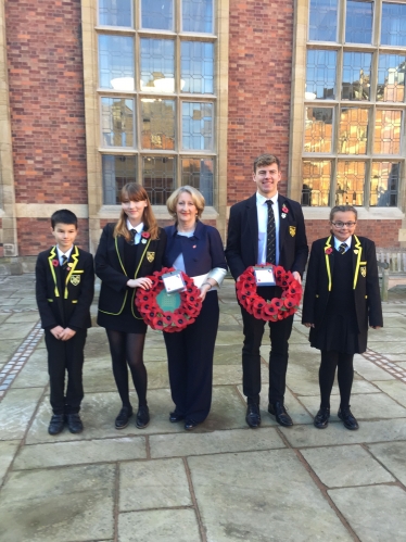 Mary Robinson pictured holding a wreath with pupils of Stockport Grammar